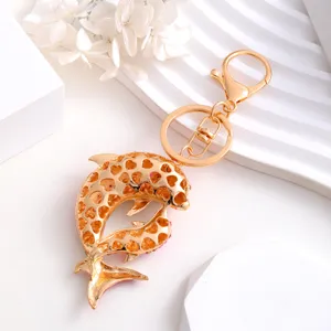 Detailed close-up view of the golden rhinestone dolphin keychain pendant details.