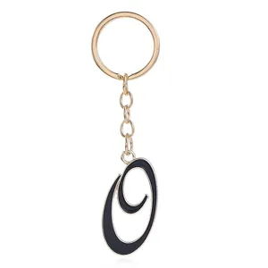 Detail view of a stylish gold metal keychain featuring a chic black enamel letter O pendant.