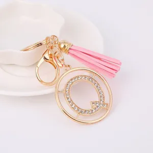 Detail shot of a sparkling rhinestone letter Q keychain with pink tassel and gold hardware.