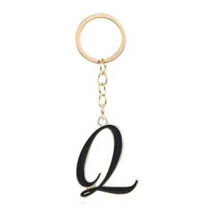 Close-up detail of the stylish gold-tone metal and black enamel letter Q keychain pendant.