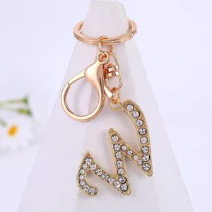 Gold rhinestone letter keychain close-up detail, sparkling crystal alphabet pendant hardware.