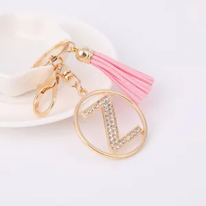 Close-up detail view of the gold rhinestone letter Z keychain featuring a pink tassel pendant.