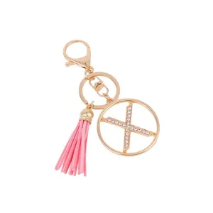 Close-up detail of a fashion gold metal rhinestone letter X pink tassel keychain pendant.