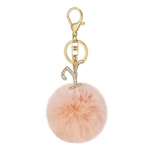 Fluffy pink pom pom keychain detail, gold clasp and sparkling rhinestone letter Y pendant.