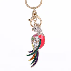 Detail view of sparkly rhinestone parrot keychain, elegant metal bird bag pendant and key ring.