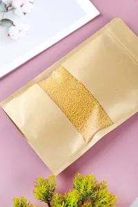 Detailaufnahme eines Standbeutels aus Kraftpapier mit Sichtfenster für gelbe Hirse