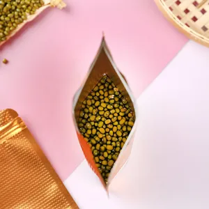 Draufsicht auf offener, dunkelgold geprägter Aluminiumfolien-Standbeutel gefüllt mit Mungbohnen