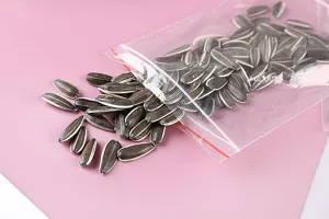Macro view of transparent PE ziplock bag with red seal containing sunflower seeds