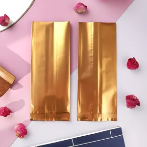 Detailaufnahme von zwei mattgoldenen Seitenfaltenbeuteln aus Aluminiumfolie für Tee