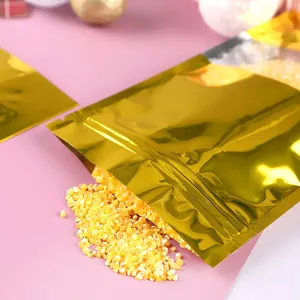 Detailansicht eines goldenen Alufolienbeutels mit Fenster und gelbem Lebensmittelgranulat