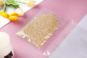 Nahaufnahme eines transparenten PE-Nylon-Vakuumbeutels, gefüllt mit Getreidekörnern auf Rosa