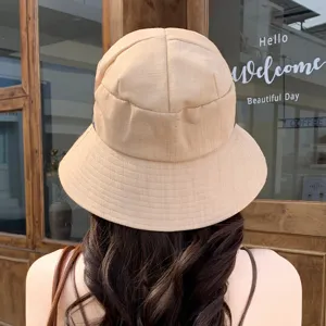 Detail view of a khaki bucket hat with pleated design, casual sun protection style.