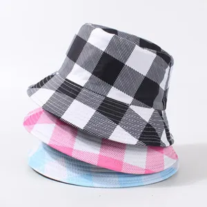 Gros plan détaillé sur trois bobs à carreaux superposés aux motifs noir, rose et bleu.