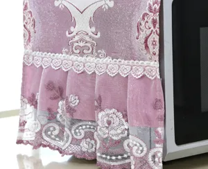 Primo piano della copertura antipolvere per microonde rosa con pizzo bianco delicato.