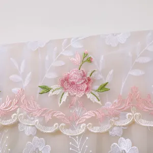 Dettaglio copertina antipolvere per condizionatore in pizzo ricamato con elegante motivo floreale.
