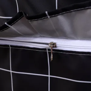 Detalle de funda impermeable para lavadora, tela oxford de cuadros negros con cremallera blanca.