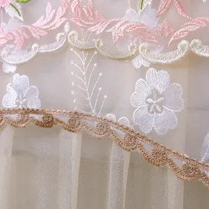 Vista dettagliata del tessuto in tulle con ricamo floreale per copertura condizionatore.