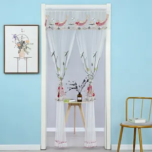 Cortina de puerta de malla blanca con delicado bordado de peces y loto en detalle.