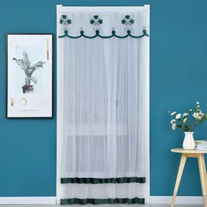 Detail view of white gauze door curtain with green embroidery and ribbon trim for summer.