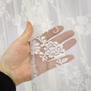 White lace sheer curtain detail showing delicate floral pattern and translucent texture.