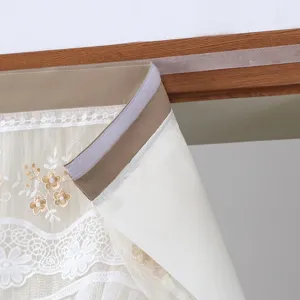 Short curtain detail showing white floral lace embroidery and punch-free velcro mounting strap.