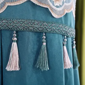 Dettaglio della copertura per condizionatore verticale in velluto verde, ricamo e nappe.
