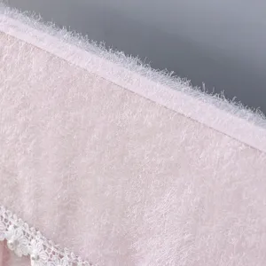 Pink plush fabric texture detail with white lace and pearl trim for decorative home decor.