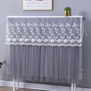 Detailaufnahme der grauen Tüll-Heizkörperabdeckung mit zarter weißer Spitzen-Blumenstickerei.