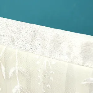 Detailansicht der weißen spitzenbestickten TV-Staubschutzhülle, zartes florales Mesh-Design.