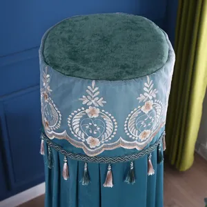Copertura antipolvere cilindrica in velluto verde per condizionatore con bordo in pizzo e nappe.