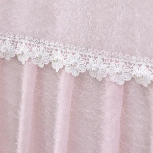 Close-up detail of pink plush fabric TV dust cover with white floral lace trim pearls.