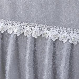 Grey fluffy TV dust cover detail featuring elegant white lace trim decorated with pearls.