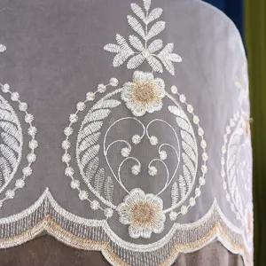Vista dettagliata dello squisito ricamo floreale sull'elegante copricondizionatore in rete.