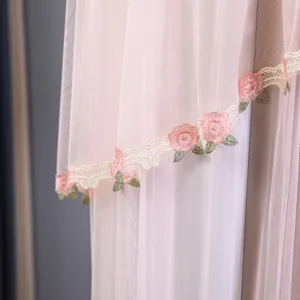 Dettaglio in primo piano di tessuto in tulle rosa per copricondizionatore, delicato ricamo floreale.