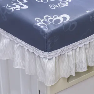 Primo piano della copertura per lavatrice in PU blu con elegante bordo in pizzo bianco.