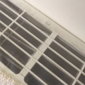 Gros plan d'une housse anti-poussière pour climatiseur mural avec bordure en dentelle.