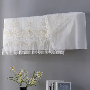 Detailed view of white lace embroidered air conditioner dust cover hanging on wall.
