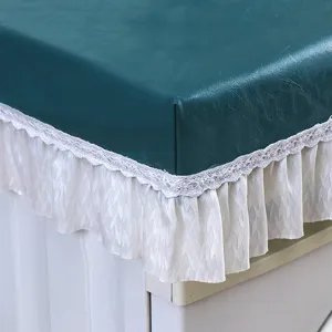 Primo piano di una copertura per lavatrice in pelle PU verde scuro con elegante bordo in pizzo.