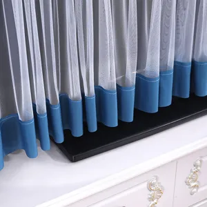 Primo piano dettagliato della copertura TV in pizzo bianco con rete fine e orlo blu.