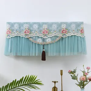 Dettaglio della copertura antipolvere per condizionatore in pizzo blu con ricamo floreale.