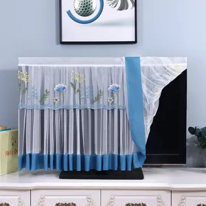Vista dettagliata della copertura antipolvere per TV in pizzo con ricamo floreale e bordo blu.