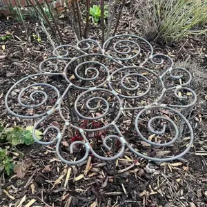 Blumenförmige Metall-Pflanzenstütze im Garten