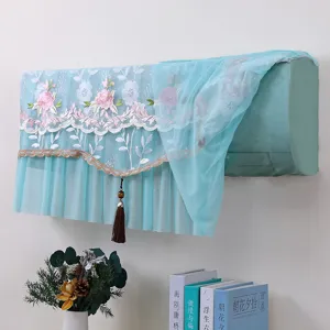 Vista dettagliata di una copertura antipolvere per condizionatore in pizzo blu con ricamo floreale.