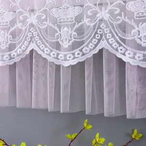 Vista dettagliata di ricamo di corona in pizzo bianco con copertura antipolvere rosa.