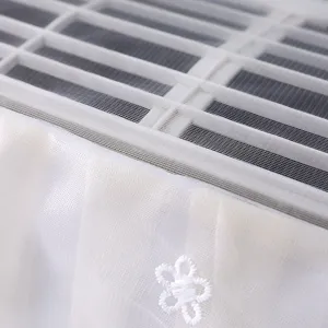 Primo piano dettagliato della copertura antipolvere in rete di pizzo bianco con ricamo.