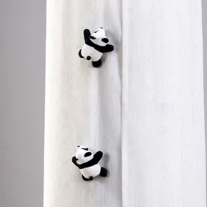 Dettaglio peluche panda cartone animato, morbida trama di tessuto per decorazione domestica.