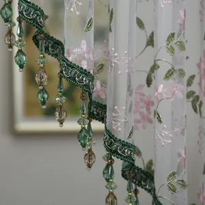 Exquisite french lace sheer curtain detail with pink floral embroidery and hanging bead fringe.