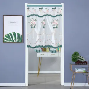 Detalle de la cortina de puerta transparente con bordado floral y elegante lazo verde.