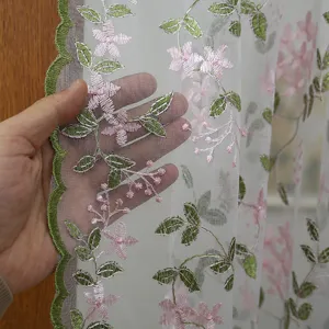 Close-up of French lace sheer curtain with pink floral embroidery and scalloped edge detail.