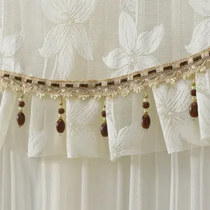 Lace door curtain detail close-up showing exquisite gold trim and brown hanging beads.